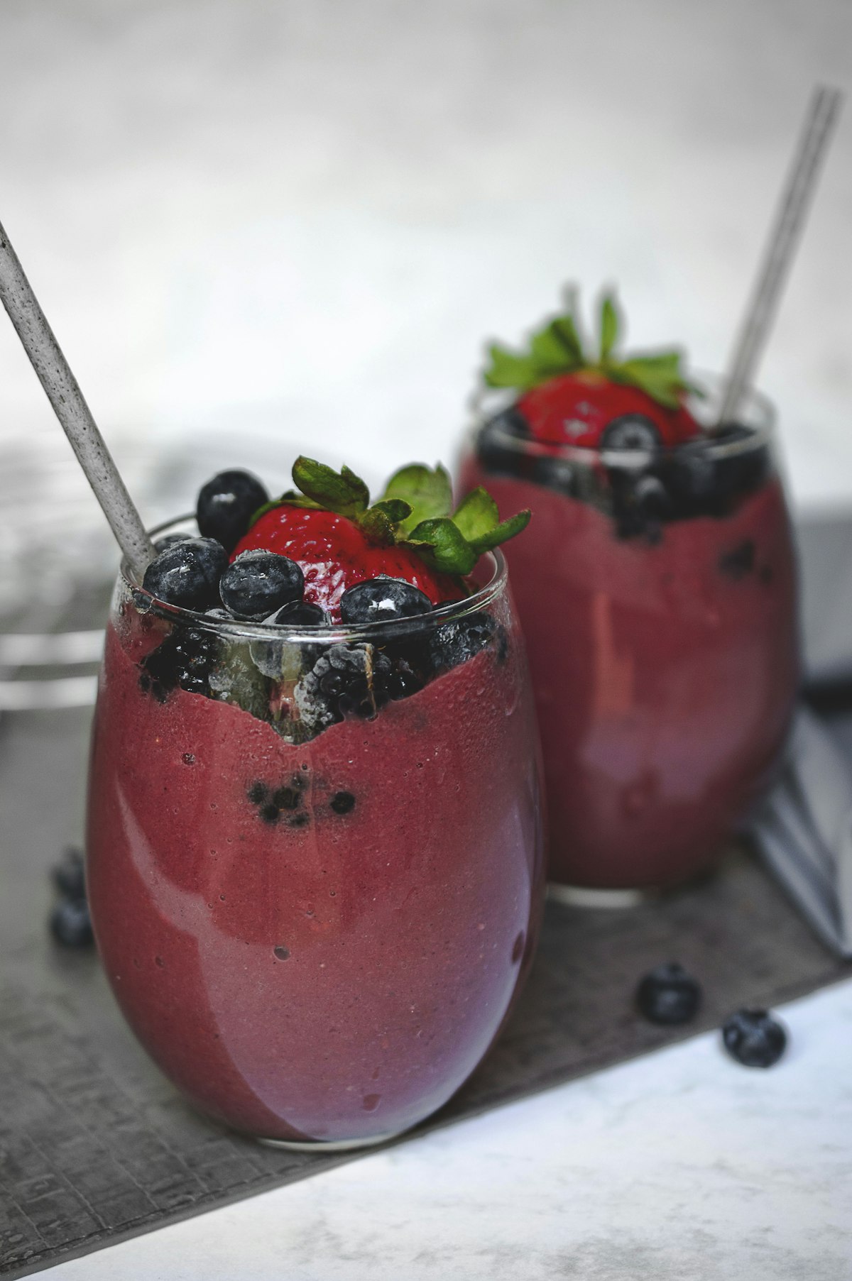 Berry smoothie topped with a strawberry and blueberries